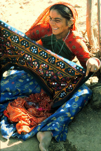 Indian woman holds fabric in her hands laughing